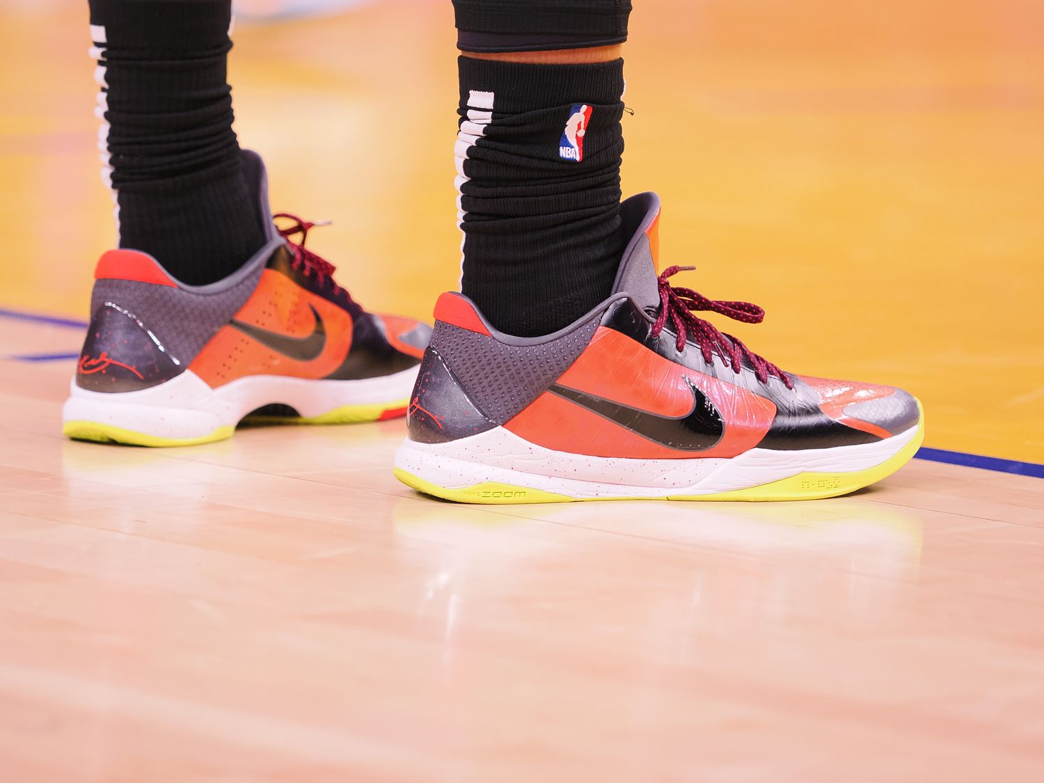 View of orange and black Nike Kobe shoes.